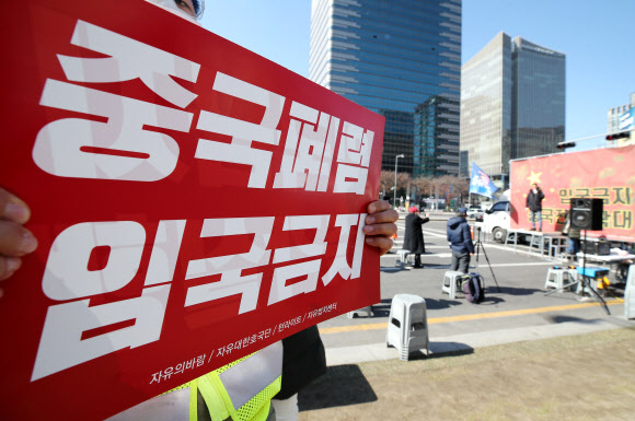 신종 코로나바이러스 감염증(코로나19) 확산이 우려되는 23일 오후 서울 청계광장 인근에서 열린 자유대한호국단 주최 ‘입국금지 조치 중국 전역 확대 촉구’ 집회에서 참석자들이 손피켓을 들고 있다. 2020.2.23  연합뉴스