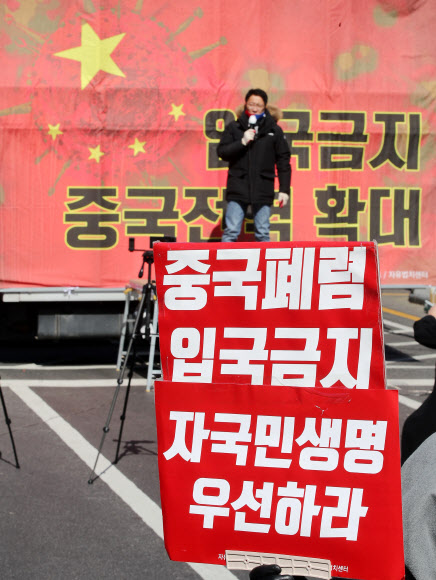 신종 코로나바이러스 감염증(코로나19) 확산이 우려되는 23일 오후 서울 청계광장 인근에서 열린 자유대한호국단 주최 ‘입국금지 조치 중국 전역 확대 촉구’ 집회에서 참석자가 손피켓을 들고 있다. 2020.2.23  연합뉴스