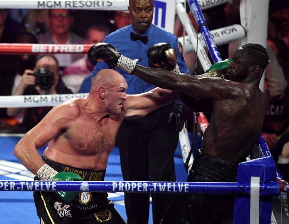 영국 출신 복서 타이슨 퓨리(왼쪽)가 22일(현지시간) 미국 네바다주 라스베이거스의 MGM 그랜드 가든 아레나에서 열린 디온테이 와일더와의 세계복싱평의회(WBC) 헤비급 타이틀전에서 난타전을 벌이고 있다. AFP 연합뉴스