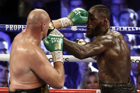 영국 출신 복서 타이슨 퓨리(왼쪽)가 22일(현지시간) 미국 네바다주 라스베이거스의 MGM 그랜드 가든 아레나에서 열린 디온테이 와일더와의 세계복싱평의회(WBC) 헤비급 타이틀전에서 난타전을 벌이고 있다. EPA 연합뉴스
