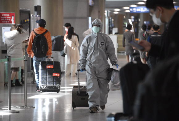 24일 인천공항에 방역복을 입고 입국한 중국유학생이 공항을 빠져나가고 있다. 2020. 2.24. 오장환 기자 5zzang@seoul.co.kr