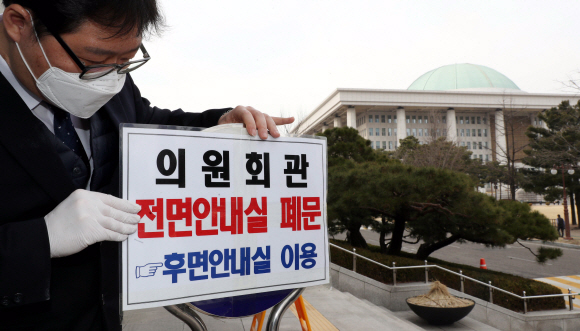 24일 국회 직원들이 의원회관 안내실 폐문을 알리는 문구를 붙이고있다. 2020. 2. 24. 정연호 기자 tpgod@seoul.co.kr