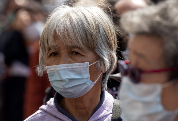 홍콩 주민들이 22일 무료로 나눠주는 마스크를 받기 위해 줄을 서고 있다. 2020.2.22  EPA 연합뉴스