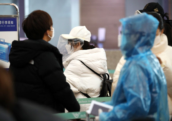 비닐 모자와 우의로 중무장한 외국인 관광객