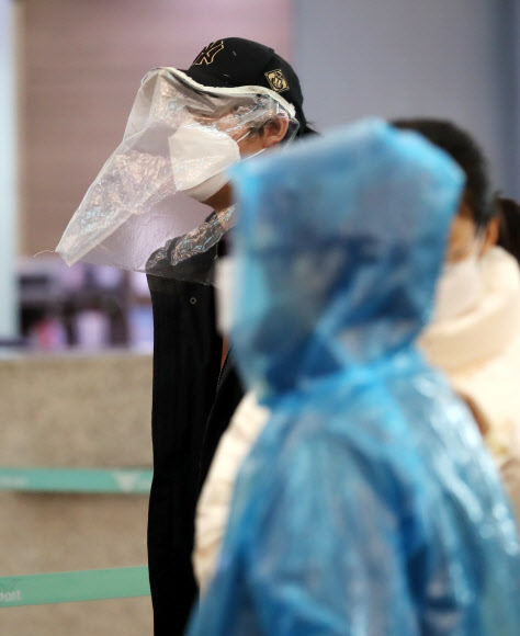 비닐 모자와 우의로 중무장한 외국인 관광객