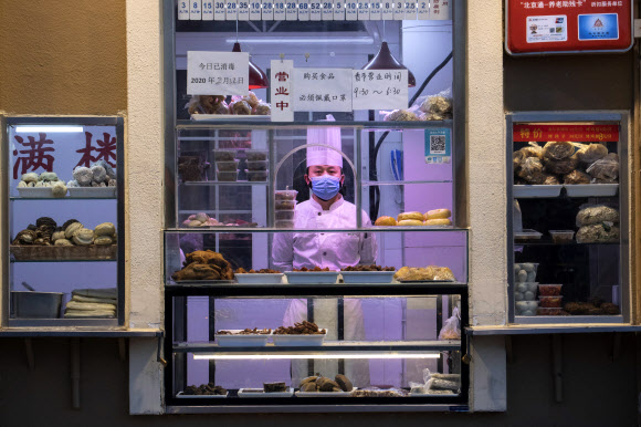 지난 22일 중국 베이징의 한 식당에서 요리사가 선 채 창밖을 응시하고 있다. AP통신