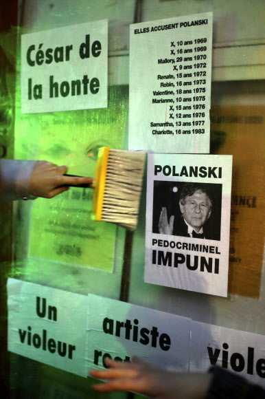 프랑스의 한 여성이 28일(현지시간) 파리 시내 살 플레옐 극장에서 제45회 세자르상 시상식이 열리기 전에 “폴란스키, 아동 범죄를 저지르고도 처벌받지 않은”이라고 적힌 플래카드를 벽에다 붙이고 있다. 파리 AP 연합뉴스 