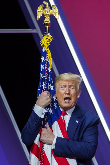 도널드 J. 트럼프 미국 대통령이 29일(현지시간) 미국 메릴랜드주 내셔널 하버에서 열린 ‘제 47회 보수정치행동회의(CPAC)(the 47th annual Conservative Political Action Conference (CPAC))’에서 연설 후, 미국 국기를 껴안고 있다. EPA 연합뉴스