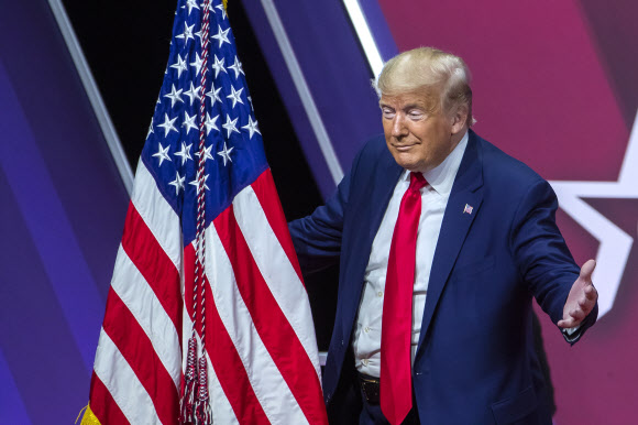 도널드 J. 트럼프 미국 대통령이 29일(현지시간) 미국 메릴랜드주 내셔널 하버에서 열린 ‘제 47회 보수정치행동회의(CPAC)(the 47th annual Conservative Political Action Conference (CPAC))’에서 연설 후, 미국 국기를 껴안고 있다. EPA 연합뉴스