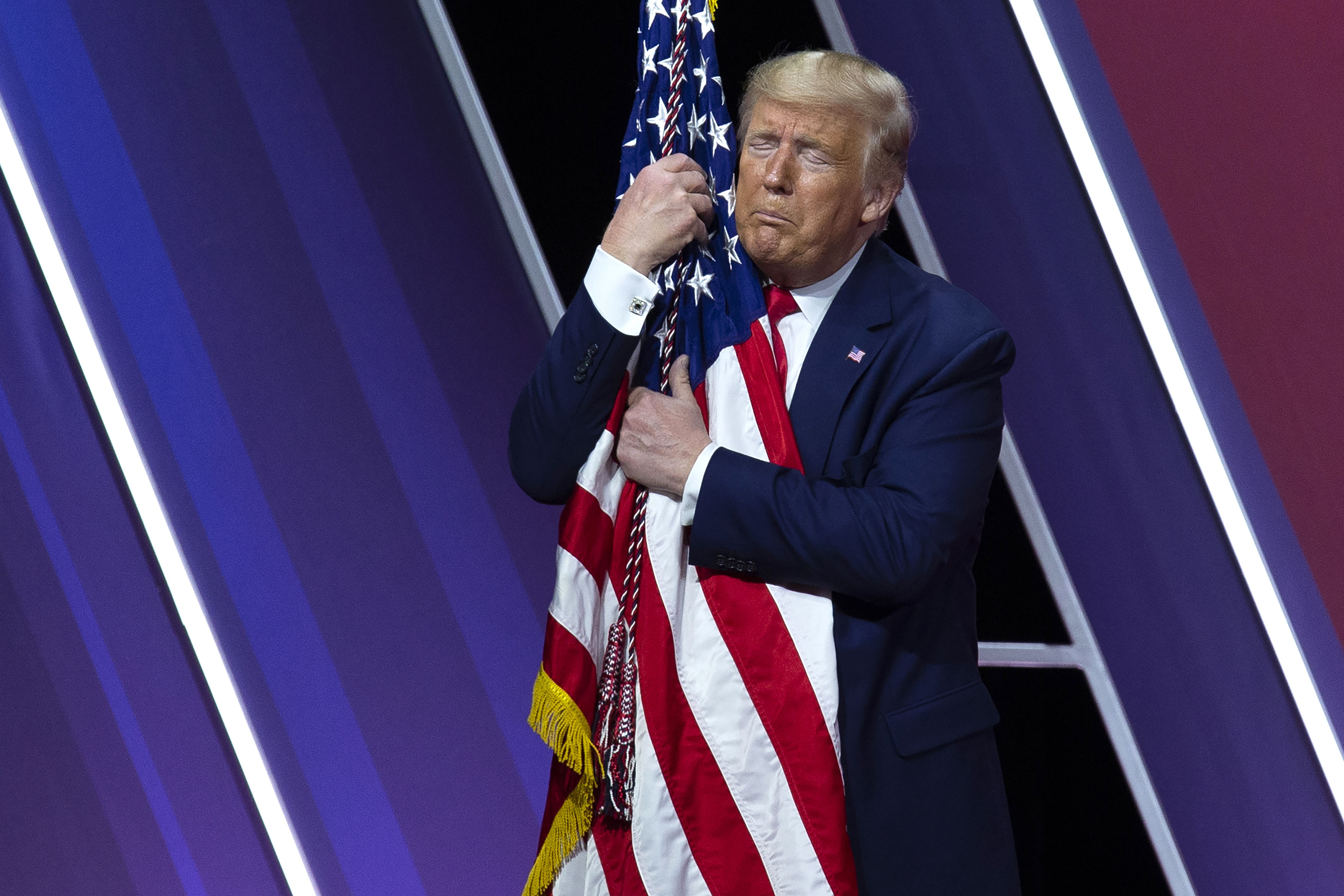 도널드 J. 트럼프 미국 대통령이 29일(현지시간) 미국 메릴랜드주 내셔널 하버에서 열린 ‘제 47회 보수정치행동회의(CPAC)(the 47th annual Conservative Political Action Conference (CPAC))’에서 연설 후, 미국 국기를 껴안고 있다. AP 연합뉴스