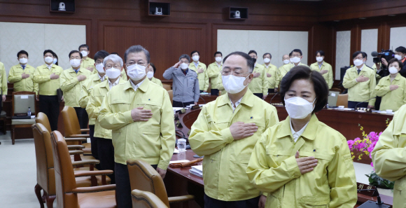 3일 문재인(오른쪽 세 번째) 대통령 주재로 열린 국무회의에서 국무위원들이 전원 민방위복 차림으로 마스크를 쓴 채 국기에 대한 경례를 하고 있다. 도준석 기자 pado@seoul.co.kr