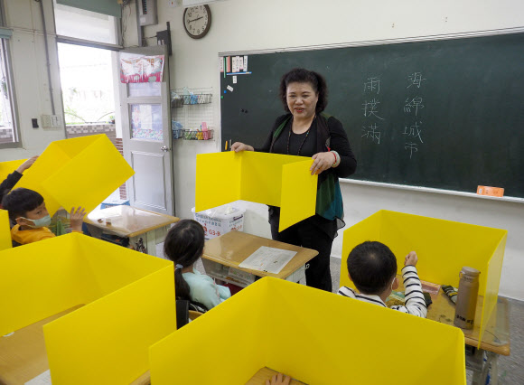 대만의 한 초등학교에서 코로나19 감염 예방을 위해 학생들에게 개인 차단막을 나눠주고 있다. 2020.3.3  EPA 연합뉴스