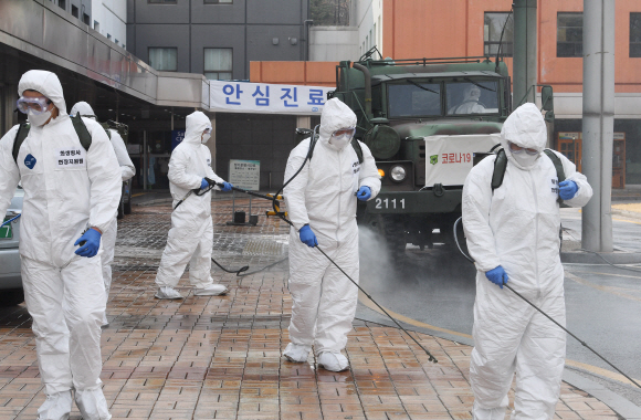 코로나 19 확산이 지속되는 4일 서울 강남구 서울성모병원 내 선별진료소 앞에서 서초구청 관계자들과 국군화생방방호사령부 특임대 도로건물방역팀이 신형 제독차와 중형 제독기를 이용해 방역 작업을 하고 있다. 2020.3.4 오장환 기자 5zzang@seoul.co.kr