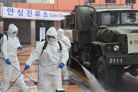코로나 19 확산이 지속되는 4일 서울 강남구 서울성모병원 내 선별진료소 앞에서 서초구청 관계자들과 국군화생방방호사령부 특임대 도로건물방역팀이 신형 제독차와 중형 제독기를 이용해 방역 작업을 하고 있다. 2020.3.4 오장환 기자 5zzang@seoul.co.kr
