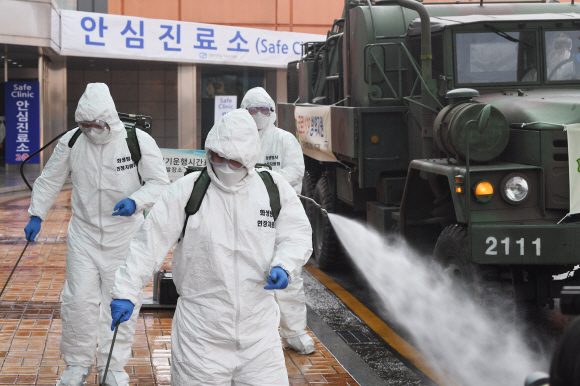 코로나 19 확산이 지속되는 4일 서울 강남구 서울성모병원 내 선별진료소 앞에서 서초구청 관계자들과 국군화생방방호사령부 특임대 도로건물방역팀이 신형 제독차와 중형 제독기를 이용해 방역 작업을 하고 있다. 2020.3.4 오장환 기자 5zzang@seoul.co.kr