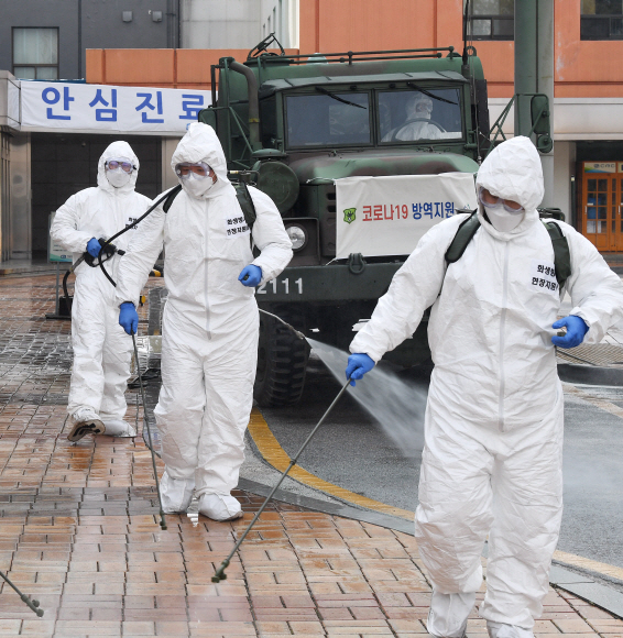 코로나 19 확산이 지속되는 4일 서울 강남구 서울성모병원 내 선별진료소 앞에서 서초구청 관계자들과 국군화생방방호사령부 특임대 도로건물방역팀이 신형 제독차와 중형 제독기를 이용해 방역 작업을 하고 있다. 2020.3.4 오장환 기자 5zzang@seoul.co.kr