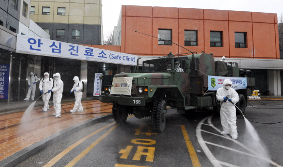 코로나 19 확산이 지속되는 4일 서울 강남구 서울성모병원 내 선별진료소 앞에서 서초구청 관계자들과 국군화생방방호사령부 특임대 도로건물방역팀이 신형 제독차와 중형 제독기를 이용해 방역 작업을 하고 있다. 2020.3.4 오장환 기자 5zzang@seoul.co.kr