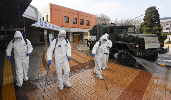 코로나 19 확산이 지속되는 4일 서울 강남구 서울성모병원 내 선별진료소 앞에서 서초구청 관계자들과 국군화생방방호사령부 특임대 도로건물방역팀이 신형 제독차와 중형 제독기를 이용해 방역 작업을 하고 있다. 2020.3.4 오장환 기자 5zzang@seoul.co.kr