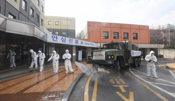 코로나 19 확산이 지속되는 4일 서울 강남구 서울성모병원 내 선별진료소 앞에서 서초구청 관계자들과 국군화생방방호사령부 특임대 도로건물방역팀이 신형 제독차와 중형 제독기를 이용해 방역 작업을 하고 있다. 2020.3.4 오장환 기자 5zzang@seoul.co.kr
