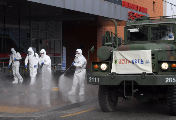 코로나 19 확산이 지속되는 4일 서울 강남구 서울성모병원 응급의료센터 앞에서 서초구청 관계자들과 국군화생방방호사령부 특임대 도로건물방역팀이 신형 제독차와 중형 제독기를 이용해 방역 작업을 하고 있다. 2020.3.4 오장환 기자 5zzang@seoul.co.kr