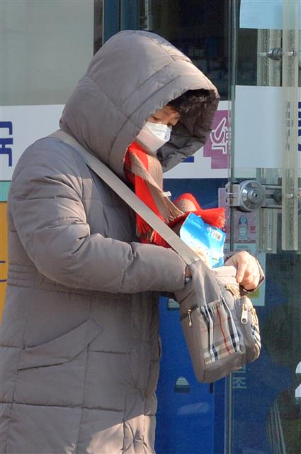 5일 오전 경북 포항시 남구 연일읍에 있는 한 약국에서 마스크를 구입한 시민이 가방에 소중히 담고 있다. 포항시는 이날 공적 마스크를 관내 약국에서 판매를 시작한다. 2020.3.5 뉴스1