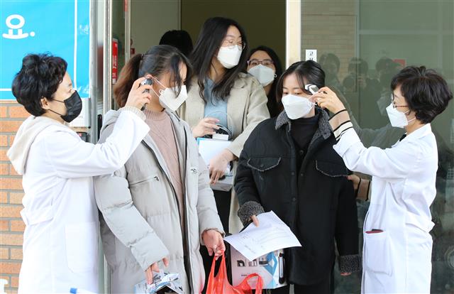 5일 오전 대전대학교 생활관에서 2주간의 격리 생활을 마친 중국인 유학생들이 생활관을 나서며 발열검사를 받고 있다. 2020.3.5 뉴스1