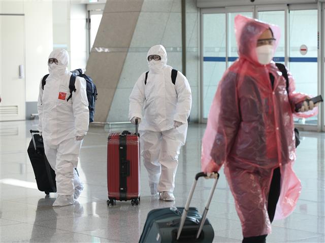신종 코로나바이러스 감염증(코로나19)이 확산하고 있는 가운데 5일 인천국제공항 1터미널에서 탑승객들이 방호복으로 무장한 채 출국장으로 향하고 있다. 2020.3.5 뉴스1