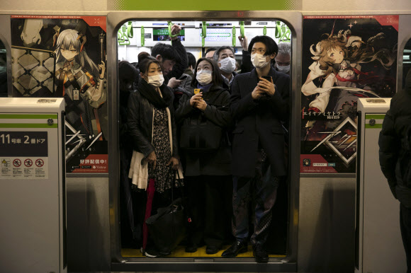 2일 일본 도쿄의 시나가와역에서 코로나19 예방을 위해 마스크를 쓴 시민들이 지하철을 타고 있다. 2020.3.2  AP 연합뉴스