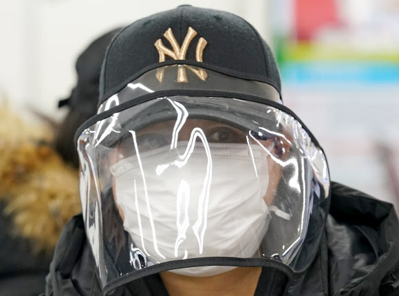 6일 오전 서울 양천구 서울남부출입국외국인사무소에서 불법체류자 자진 출국 신고를 하기 위해 대기하던 외국인이 마스크와 페이스 쉴드가 달린 모자를 쓰고 있다. 2020.3.6  연합뉴스