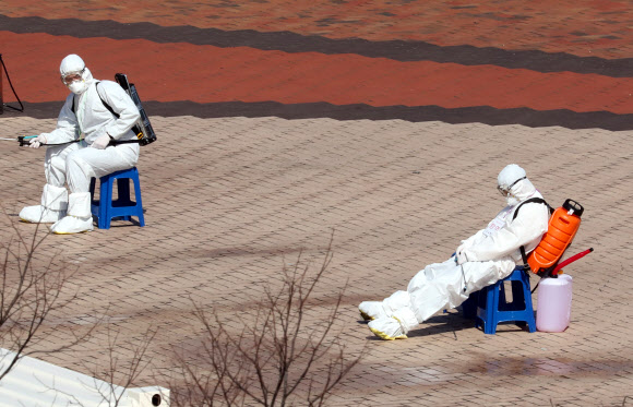6일 오후 대구시 수성구 노변동 대구스타디움에 마련된 119구급차 집결지에서 구급차 방역 임무를 맡은 대원이 소독약품통을 등에 멘 채로 잠시 휴식을 취하고 있다. 2020.3.6  연합뉴스