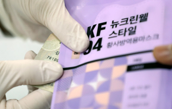 신종 코로나바이러스 감염증(코로나19) 예방을 위해 공적 마스크를 배분하는 ‘마스크 5부제’ 시행 첫날인 9일 오전 대구시 수성구 범어동의 한 약국에서 주민등록번호 년도 끝자리가 6인 시민이 마스크를 구매하고 있다. 마스크 5부제에 따라 월요일 1·6년, 화요일 2·7년, 수요일 3·8년, 목요일 4·9년, 금요일 5·0년으로 출생연도가 끝나는 이들이 약국에서 마스크를 2매 살 수 있다. 2020.3.9  연합뉴스