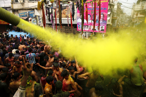 인도인들이 10일(현지시간) 인도 프라야그라즈에서 힌두교의 색채 축제인 ‘홀리’를 기념하며 색 스프레이 물에 흠뻑 젖어 춤을 추고 있다. AP 연합뉴스