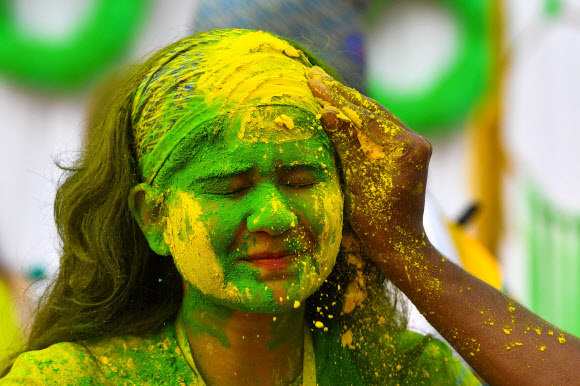 인도인들이 10일(현지시간) 인도 프라야그라즈에서 힌두교의 색채 축제인 ‘홀리’를 기념하며 색 스프레이 물에 흠뻑 젖어 춤을 추고 있다. AFP 연합뉴스