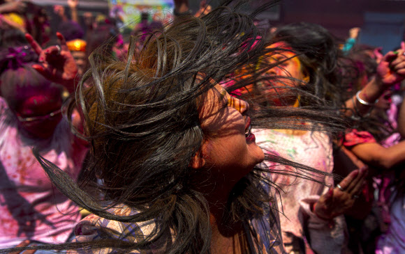 인도인들이 10일(현지시간) 인도 프라야그라즈에서 힌두교의 색채 축제인 ‘홀리’를 기념하며 색 스프레이 물에 흠뻑 젖어 춤을 추고 있다. AP 연합뉴스