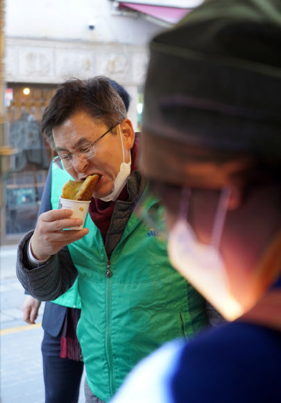 서울 종로에 출마하는 미래통합당 황교안 대표가 11일 서울 종로구 가회동에서 방역활동을 하던 중 호떡을 먹고 있다.  2020.3.11   황교안측 제공