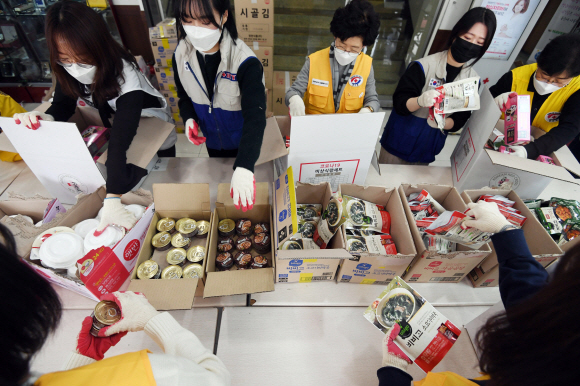 대한적십자 직원들과 봉사자들이 12일 서울 성동구 대한적십자사 서울지사에서 코로나19 대응 감염병 취약계층 긴급구호품 지원을 위한 포장 작업을 하고 있다. 2020.3.12 박윤슬 기자 seul@seoul.co.kr