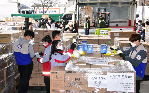 12일 인천 중구 현대로지스앤팩 창고 내 한진물류창고에서 대한적십자사 관계자들이 중국 전자상거래 업체 ‘알리바바’의 창업자 마윈(Ma Yun) 전 회장이 기부한 마스크 100만장을 검수 및 통관작업을 하고 있다. 이번 기부는 마윈 전 회장이 설립한 마윈공익기금회와 알리바바공익기금회가 한국의 신종 코로나바이러스 감염증(코로나19) 극복에 힘을 더하고자 이뤄졌다.  2020.3.12 이종원 선임기자 jongwon@seoul.co.kr