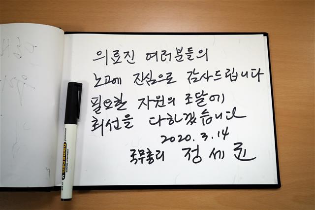 정세균 국무총리가 14일 오전 신종 코로나바이러스 감염증(코로나19) 확진자 진료 지역거점병원인 대구 중구 계명대 대구동산병원을 찾아 비상대책본부에 마련된 방명록에 감사와 응원의 메시지를 남겼다. 2020.3.14 뉴스1