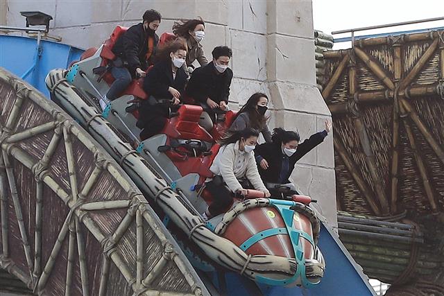 주말인 14일 서울 송파구 롯데월드에서 마스크를 쓴 시민들이 놀이기구를 타고 있다. 2020.3.14 뉴스1