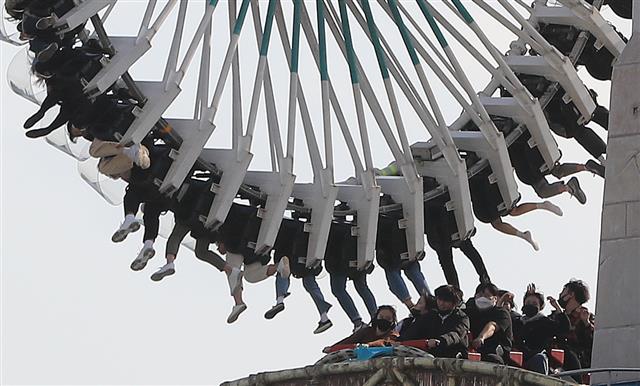 주말인 14일 서울 송파구 롯데월드에서 마스크를 쓴 시민들이 놀이기구를 타고 있다. 2020.3.14 뉴스1