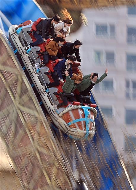 주말인 14일 서울 송파구 롯데월드에서 마스크를 쓴 시민들이 놀이기구를 타고 있다. 2020.3.14 뉴스1