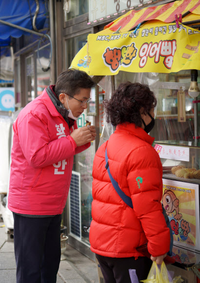서울 종로에 출마하는 미래통합당 황교안 대표가 15일 서울 종로구 청운·효자동 골목에서 주민들을 만나 인사하던 도중 잉어빵을 먹고 있다.  2020.3.15    황교안측 제공