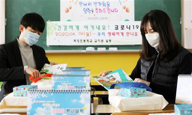 교육부가 신종 코로나바이러스 감염증(코로나19) 확산을 방지하기 위해 유치원과 초·중·고등학교 개학 연기를 발표한 17일 오후 경기도 수원시 파장초등학교에서 교사들이 새롭게 입학하는 아이들에게 줄 교과서 및 선물을 정리하고 있다.  당초 이달 9일과 23일로 잇따라 연기됐던 전국 유치원과 초·중·고등학교의 개학은 2주 뒤인 4월 6일로 추가 연기됐다. 2020.3.17 뉴스1
