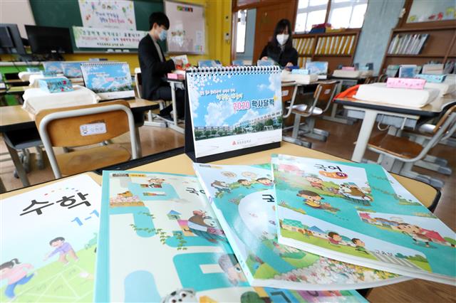 교육부가 신종 코로나바이러스 감염증(코로나19) 확산을 방지하기 위해 유치원과 초·중·고등학교 개학 연기를 발표한 17일 오후 경기도 수원시 파장초등학교에서 교사들이 새롭게 입학하는 아이들에게 줄 교과서 및 선물을 정리하고 있다.  당초 이달 9일과 23일로 잇따라 연기됐던 전국 유치원과 초·중·고등학교의 개학은 2주 뒤인 4월 6일로 추가 연기됐다. 2020.3.17 뉴스1