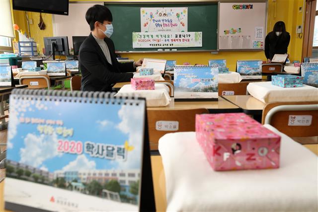 교육부가 신종 코로나바이러스 감염증(코로나19) 확산을 방지하기 위해 유치원과 초·중·고등학교 개학 연기를 발표한 17일 오후 경기도 수원시 파장초등학교에서 교사들이 새롭게 입학하는 아이들에게 줄 교과서 및 선물을 정리하고 있다.  당초 이달 9일과 23일로 잇따라 연기됐던 전국 유치원과 초·중·고등학교의 개학은 2주 뒤인 4월 6일로 추가 연기됐다. 2020.3.17 뉴스1