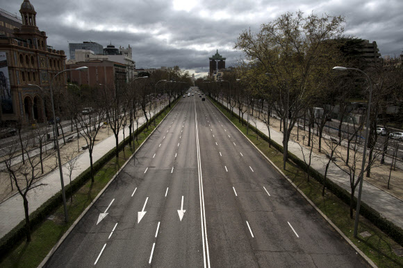 이동 제한 명령이 내려진 스페인 마드리드의 파세오 드 라 카스텔라나 일대를 통과하는 자동차 도로가 17일(현지시간) 한적하기만 하다. 마드리드 AP 연합뉴스 