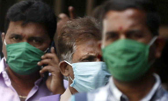 마스크를 쓴 인도 남성이 17일(현지시간) 뭄바이에 코로나19 감염 환자를 치료하기 위한 병원의 격리 병동 안으로 전화를 걸며 들어가고 있다. 뭄바이 로이터 연합뉴스 