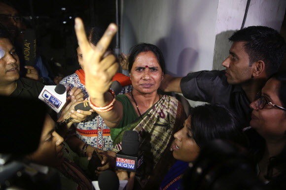 2012년 버스 집단 성폭행 사건으로 목숨을 잃은 니브르하야의 어머니 아샤 데비가 20일 가해자 4명의 사형이 집행된 뒤 승리의 V 자를 그려 보이고 있다. 델리 AP 연합뉴스