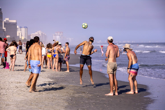 신종 코로나바이러스 감염증 확산에 따라 미국 정부가 사회적 거리두기를 권고한 가운데 19일(현지시간) 미국 사우스 캐롤라이나주 머틀 비치에는 평소와 다름없이 해변을 즐기는 사람들로 북적이고 있다. AP 연합뉴스