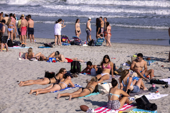 신종 코로나바이러스 감염증 확산에 따라 미국 정부가 사회적 거리두기를 권고한 가운데 19일(현지시간) 미국 사우스 캐롤라이나주 머틀 비치에는 평소와 다름없이 해변을 즐기는 사람들로 북적이고 있다. AP 연합뉴스